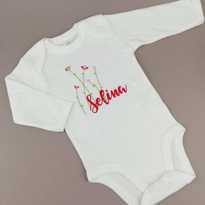 weißer Babybody bestickt mit Namen und zarten langen Blumen