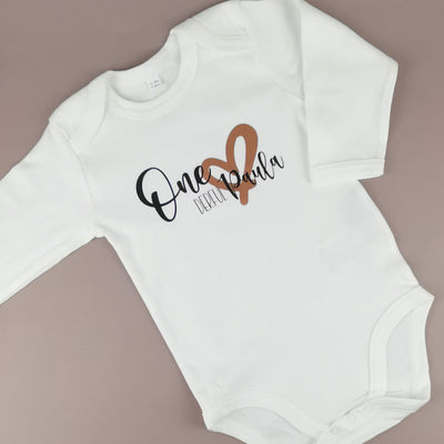 weißer Babybody bedruckt mit "onederful" und einem Namen